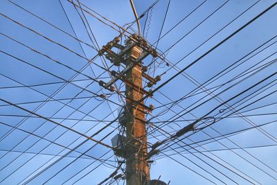 Low angle view of electricity pylon against clear sky