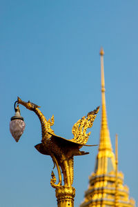 Low angle view of statue against blue sky