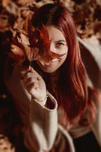Portrait of woman with red leaves during autumn