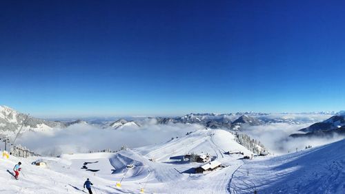 Scenic view of snow covered mountains against blue sky