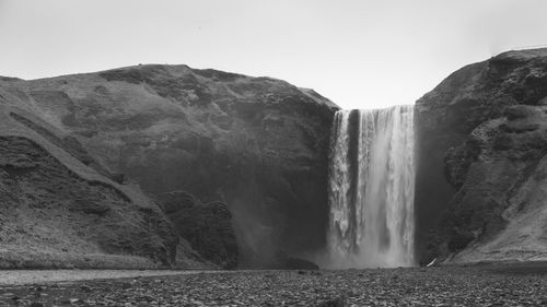 Scenic view of waterfall against sky