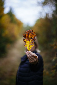 Woman showing autumn leaf in park