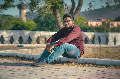 Man sitting in graden while looking away.