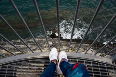 Low section of person standing on railing