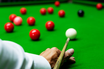 Close-up of hand playing with ball on table