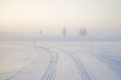 Snow covered field against sky