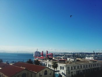 Aerial view of cityscape against clear blue sky