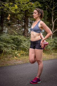 Full length of woman exercising on road