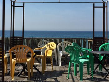 Empty chairs and tables at seaside