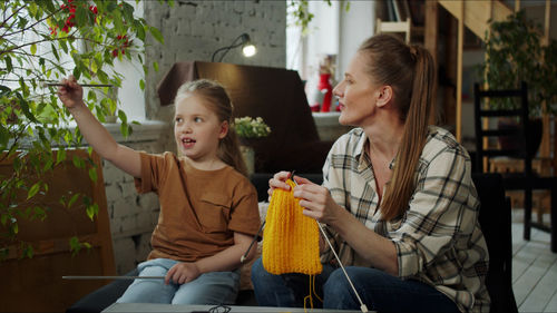 Mother teaching crocheting to daughter