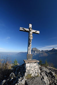 Cross on rock against blue sky