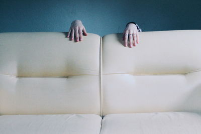 Cropped image of woman hand on sofa