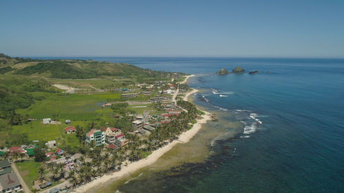 Aerial view of beautiful tropical beach with turquoise water in blue lagoon, pagudpud, philippines. 