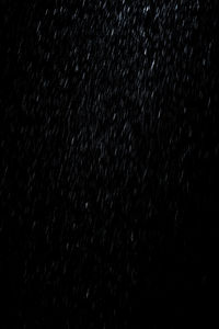 Full frame shot of raindrops in sky at night