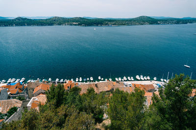 High angle view of townscape by sea against sky