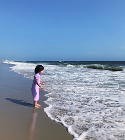 Full length of girl on beach against sky
