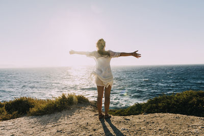 Man standing at beach against sky