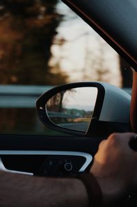 Reflection of man in side-view mirror of car