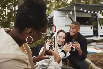 Friends having fun in front of camper van