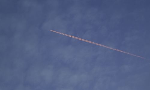 Low angle view of vapor trail against blue sky