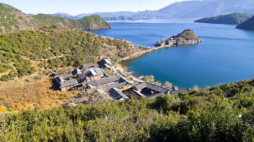 High angle view of sea and buildings against mountains