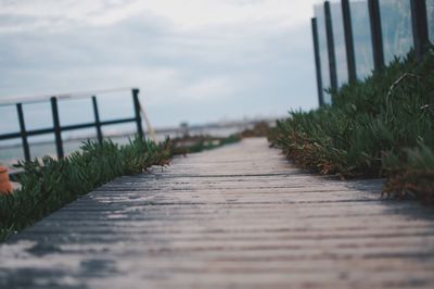 Surface level of footbridge against sky