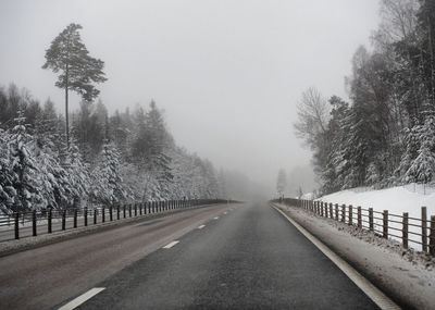 Road amidst trees against sky