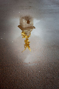 High angle view of puddle on wet street in city