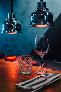 Glasses on the table in red light of infrared heat lamps in restaurant