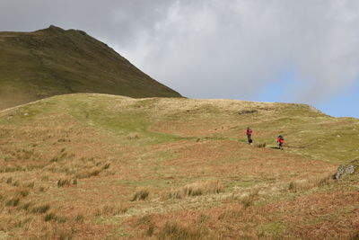 People walking on mountain against sky