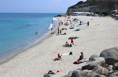 People on beach against sky