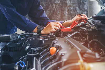 Midsection of mechanic repairing car