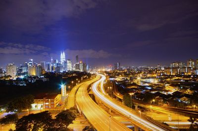 High angle view of illuminated street amidst buildings at night