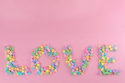 Multi colored candies against pink background