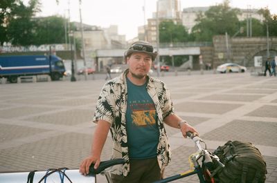 Portrait of man standing with bicycle on street