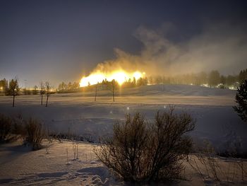 Scenic view of snow covered field against sky during winter