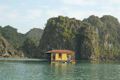 A floating house nested in between the rock formations of ha long bay, vietnam