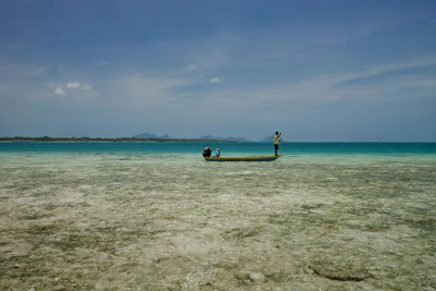 Men in sea against sky