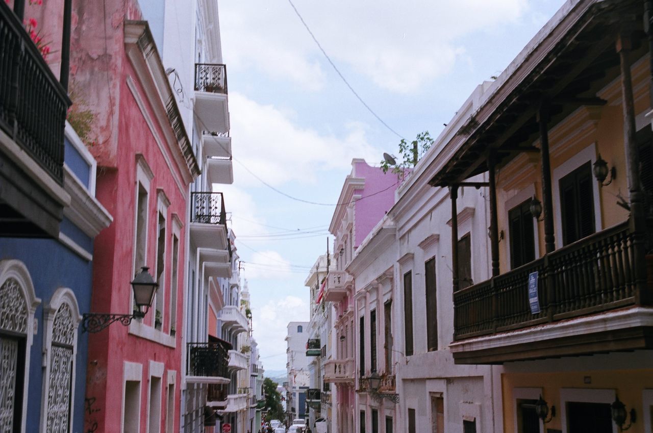 building exterior, built structure, architecture, city, building, cloud - sky, low angle view, sky, residential district, day, nature, no people, window, outdoors, street, town, house, pink color, balcony, in a row, apartment, place, location