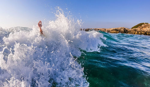 Waves splashing on sea against sky