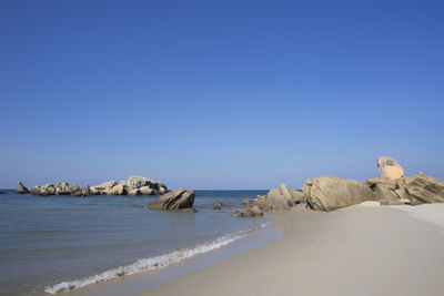 Scenic view of beach against clear blue sky