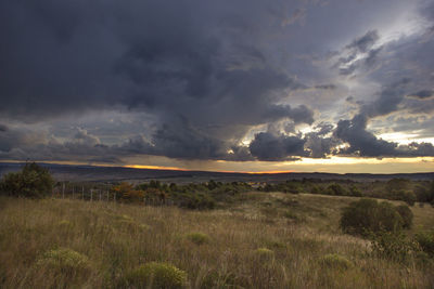 Scenic view of field against dramatic sky