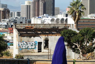 Woman in blue outfit against buildings