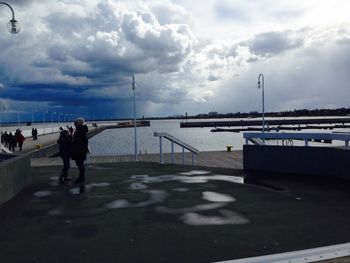 Man standing at harbor against sky