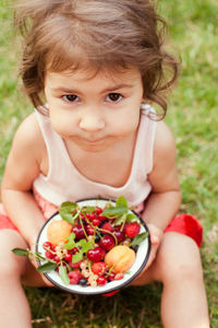 Portrait of cute baby girl holding fruits