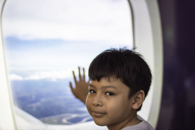 Portrait of boy looking through window