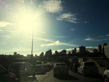 Cars on road in city against sky