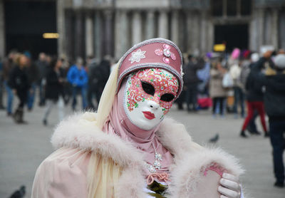 Close-up of woman with arms mask in city