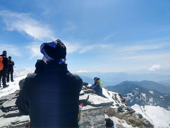 Rear view of people looking at mountain during winter