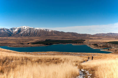 Scenic view of landscape and mountains against blue sky